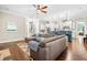 Spacious living room showcasing hardwood floors, a comfortable sectional sofa, and seamless kitchen access at 2538 Tuffeto, Apex, NC 27502
