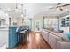 Open-concept living room featuring a kitchen island with seating, hardwood floors, and plenty of natural light at 2538 Tuffeto, Apex, NC 27502