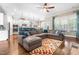 Bright living room with hardwood floors, a large sectional sofa, and an open view into the modern kitchen at 2538 Tuffeto, Apex, NC 27502