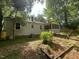 Spacious backyard showcasing the home's exterior, screened porch, mature trees, and garden beds at 26 Rogerson Dr, Chapel Hill, NC 27517