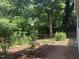 Tranquil backyard featuring established trees, shrubs, and a variety of garden beds with walking path at 26 Rogerson Dr, Chapel Hill, NC 27517