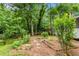 Landscaped backyard featuring a picket fence, mature trees, and a peaceful, private outdoor space at 26 Rogerson Dr, Chapel Hill, NC 27517