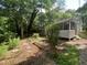 Lush backyard featuring a screened porch, multiple garden beds, trees, and manicured landscaping at 26 Rogerson Dr, Chapel Hill, NC 27517