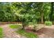 A spacious backyard, partially shaded by trees, featuring a charming picket fence and lush landscaping at 26 Rogerson Dr, Chapel Hill, NC 27517