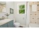 Bright bathroom featuring classic tile, a blue vanity, and a window view at 26 Rogerson Dr, Chapel Hill, NC 27517