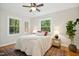 Cozy bedroom features a ceiling fan, windows, and hardwood floors at 26 Rogerson Dr, Chapel Hill, NC 27517