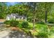 Cozy home nestled in a wooded setting features a well-manicured lawn and flowering shrubs at 26 Rogerson Dr, Chapel Hill, NC 27517