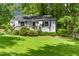 Charming single-story home features a welcoming front porch, tidy landscaping, and beautiful lawn at 26 Rogerson Dr, Chapel Hill, NC 27517