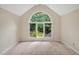 Bright bedroom with large arched window overlooking lush greenery at 2606 Sherbrooke Dr, Durham, NC 27712