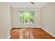 Cozy bedroom with neutral walls, large windows overlooking green foliage, and hardwood floors at 2606 Sherbrooke Dr, Durham, NC 27712
