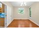 Bright dining room featuring hardwood floors, a hanging light fixture, and an open doorway to the kitchen area at 2606 Sherbrooke Dr, Durham, NC 27712