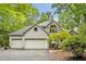 Charming two-story home featuring a stone facade, three-car garage, and lush landscaping at 2606 Sherbrooke Dr, Durham, NC 27712