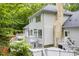 Rear exterior view of a house showcasing a spacious deck, white siding, and lush greenery at 2606 Sherbrooke Dr, Durham, NC 27712