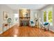 Large living room featuring a stone fireplace, hardwood floors, and an open doorway to the kitchen area at 2606 Sherbrooke Dr, Durham, NC 27712