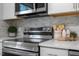 Modern stainless steel kitchen range and oven with white countertops and gray backsplash at 2612 Glenbrook Dr, Durham, NC 27704