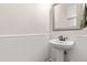 Elegant half bathroom featuring a pedestal sink, bead-board walls, and classic design at 2635 Asher View Ct, Raleigh, NC 27606