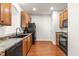 Well-equipped kitchen with wooden cabinets, black appliances, and rich hardwood flooring at 2635 Asher View Ct, Raleigh, NC 27606