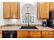 Kitchen featuring a black sink, wood cabinets, and a view into a bright living room at 2635 Asher View Ct, Raleigh, NC 27606