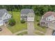 Aerial view of home with a manicured lawn, two-car garage, and mature trees at 2709 Banks Lake Ct, Fuquay Varina, NC 27526