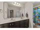 Bathroom featuring a double sink vanity, large mirror, and a shower tub with colorful shower curtain at 2709 Banks Lake Ct, Fuquay Varina, NC 27526