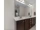 Bathroom featuring a double vanity with dark wood cabinets, a large mirror, and sleek lighting fixtures at 2709 Banks Lake Ct, Fuquay Varina, NC 27526