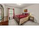 Bedroom featuring a queen bed, bedside table with lamp, dresser, and a bright window at 2709 Banks Lake Ct, Fuquay Varina, NC 27526