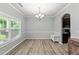 Bright dining room features hardwood floors, crown molding and modern chandelier with views of the front yard at 2709 Banks Lake Ct, Fuquay Varina, NC 27526