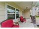 Front porch sitting area with red cushioned chairs and decorative stone pillar bases at 2709 Banks Lake Ct, Fuquay Varina, NC 27526