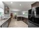 Modern kitchen with granite countertops, stainless steel appliances, dark wood cabinets, and views to the dining area at 2709 Banks Lake Ct, Fuquay Varina, NC 27526