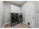Laundry room features washer, dryer, storage cabinets, and a pet door to the outside at 2709 Banks Lake Ct, Fuquay Varina, NC 27526