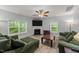 Bright living room with fireplace, large windows with backyard views, ceiling fan and hardwood floors at 2709 Banks Lake Ct, Fuquay Varina, NC 27526