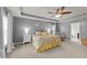 Serene main bedroom features tray ceiling, a ceiling fan, sitting area, and stylish bedside tables at 2709 Banks Lake Ct, Fuquay Varina, NC 27526