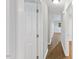 Hallway with hardwood floors, neutral paint, and multiple white doors at 2752 Weldon Ter, Durham, NC 27703