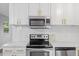 Close-up of modern kitchen with marble countertops, stainless appliances, and stylish backsplash at 2752 Weldon Ter, Durham, NC 27703