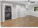 Modern laundry room with stacked washer and dryer, wood floors and ceiling fan at 2752 Weldon Ter, Durham, NC 27703