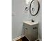 Stylish bathroom vanity with light blue walls, a round mirror, and bronze fixtures at 306 Fincastle Dr, Cary, NC 27513