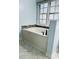 A bathtub beneath a window featuring privacy film and a mosaic tile backsplash at 306 Fincastle Dr, Cary, NC 27513