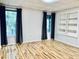 Bright bedroom featuring hardwood floors, two windows, and a built-in bookcase at 306 Fincastle Dr, Cary, NC 27513