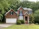 Charming brick home featuring blue shutters, a well-manicured lawn, and an attached two-car garage at 306 Fincastle Dr, Cary, NC 27513