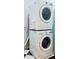 A stacked washer and dryer set in a laundry room with black and white tile flooring at 306 Fincastle Dr, Cary, NC 27513