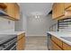 Bright kitchen featuring wood cabinetry, modern appliances, and an adjacent dining area with sleek flooring at 3077 Huntleigh Dr, Raleigh, NC 27604