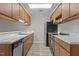 Galley style kitchen with wood cabinets, white counters, and a black refrigerator at 3077 Huntleigh Dr, Raleigh, NC 27604