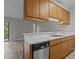 View of the kitchen and living room featuring wood cabinets, white countertops, and hardwood floors at 3077 Huntleigh Dr, Raleigh, NC 27604