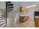 Bright living space with hardwood floors and a spiral staircase connecting the levels, next to a galley kitchen at 3077 Huntleigh Dr, Raleigh, NC 27604
