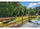 Backyard deck with seating, string lights, and view of spacious green yard with trampoline at 364 Chinaberry Ln, Angier, NC 27501