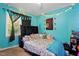 Vibrant bedroom with turquoise walls, a bed with stuffed animals, and decorative string lights at 364 Chinaberry Ln, Angier, NC 27501