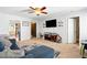 Living room featuring neutral carpet, blue sofa, ceiling fan, and access to kitchen at 364 Chinaberry Ln, Angier, NC 27501