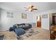 Cozy living room featuring neutral carpet, blue sofa, ceiling fan, and access to kitchen at 364 Chinaberry Ln, Angier, NC 27501