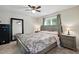 Main bedroom with neutral walls, large mirror, a bed with a patterned comforter, and side tables at 364 Chinaberry Ln, Angier, NC 27501