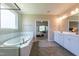 The bathroom features a soaking tub, walk-in shower, and double sinks with view to bedroom at 367 Tayside St, Clayton, NC 27520